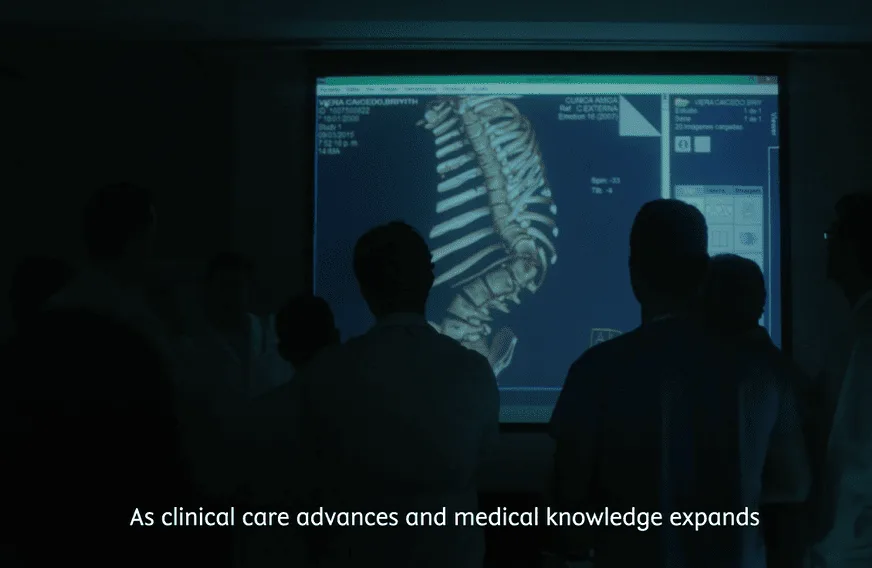 doctors in a room looking at spinal graphic